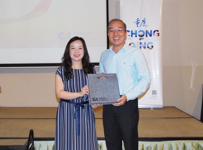 重慶機場集團市場營銷部經理唐艷向聯邦旅遊公司代表贈送幸運獎。