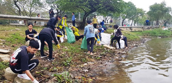 順化市年輕參與者到香河畔清理河岸沿線垃圾。（圖源：日玲）