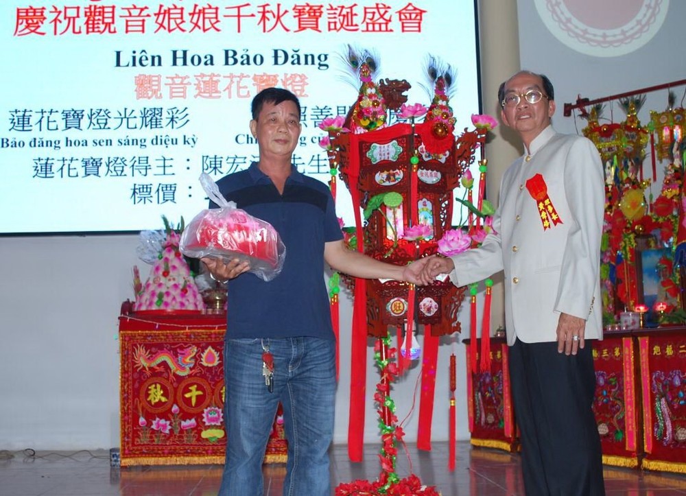 該廟理事長黃偉峰(右)向陳宏漢先生(左)轉交蓮花寶燈。
