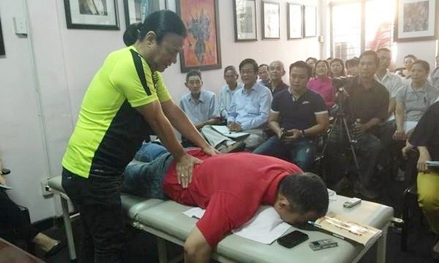劉劍昌師傅向群眾示範舒緩高齡人腰椎疼痛推拿法。