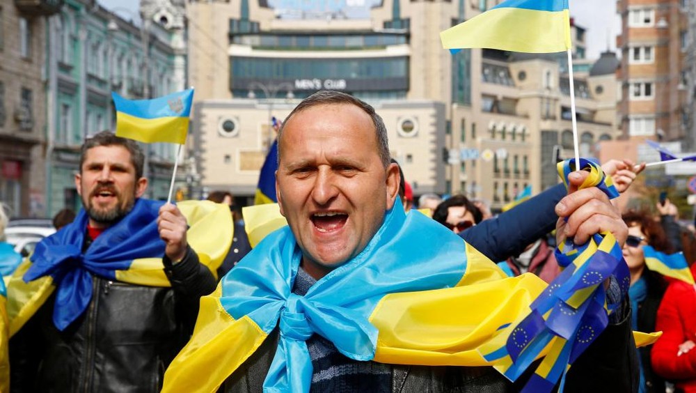 烏克蘭街頭披着國旗的民眾。（圖源：路透社）