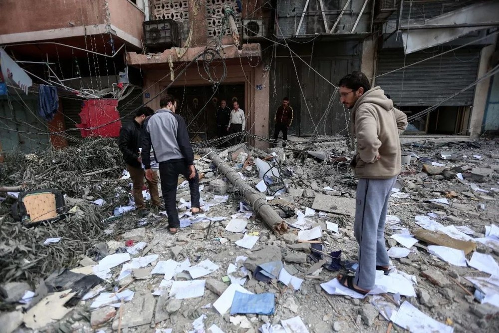 在加沙城，巴勒斯坦人查看被以軍空襲毀壞的建築。（圖源：新華社）