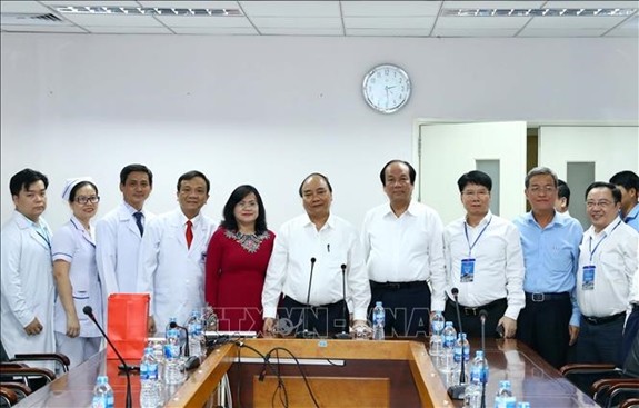政府總理阮春福（中）與同奈省全科醫院領導、醫生和幹部合影。（圖源：越通社）