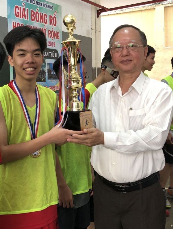 盧耀南理事長頒獎給獲第一名 的新平郡阮嘉韶學校籃球隊。