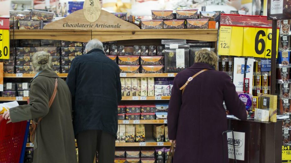 圖為民眾在超市貨架前挑選商品。 （圖源：AFP）
