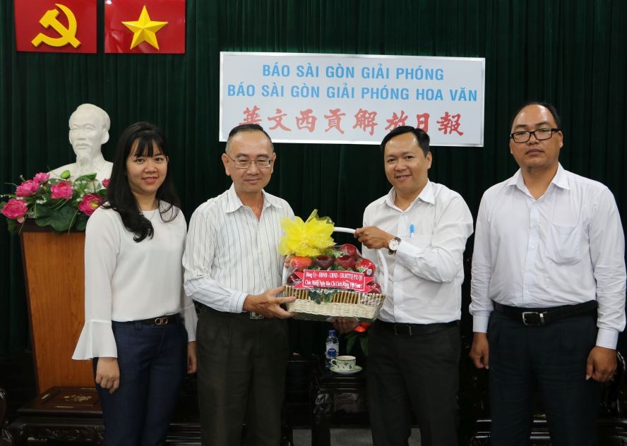 本報編輯部主任范興(左二)接受代表團的賀禮。