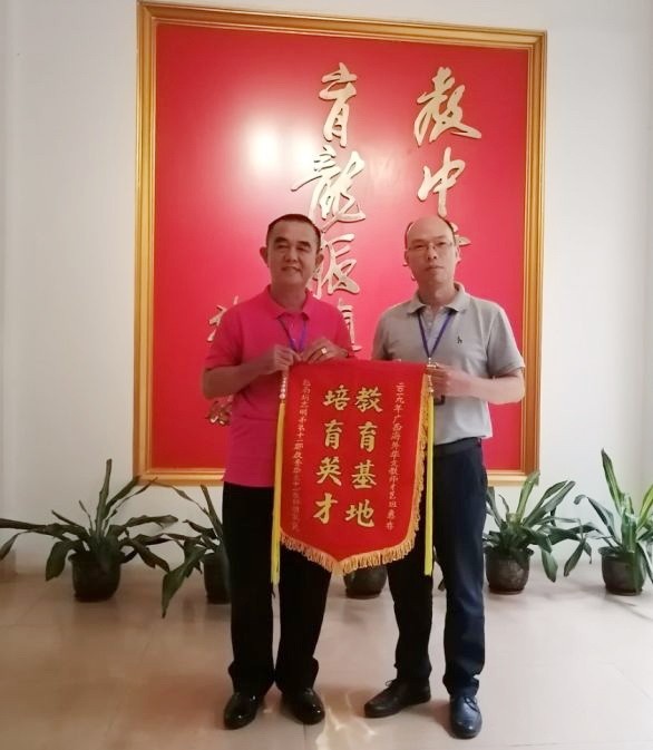 黃智球老師（左）代表本市華文老師團向組委會陳進超校長贈送紀念錦旗。