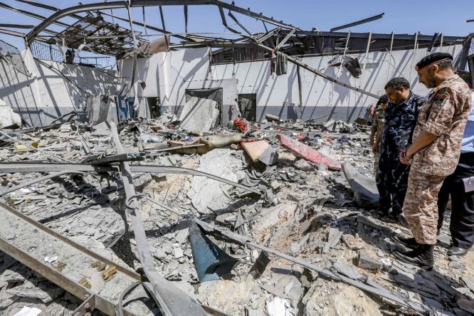  “利比亞民族團結政府”軍官到遇襲難民收容所檢查損毀情況。（圖源：AFP）