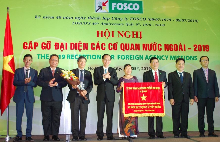 市人委會常務副主席黎清廉(左四)代表市人委會向FOSCO公司贈送傳統錦旗。