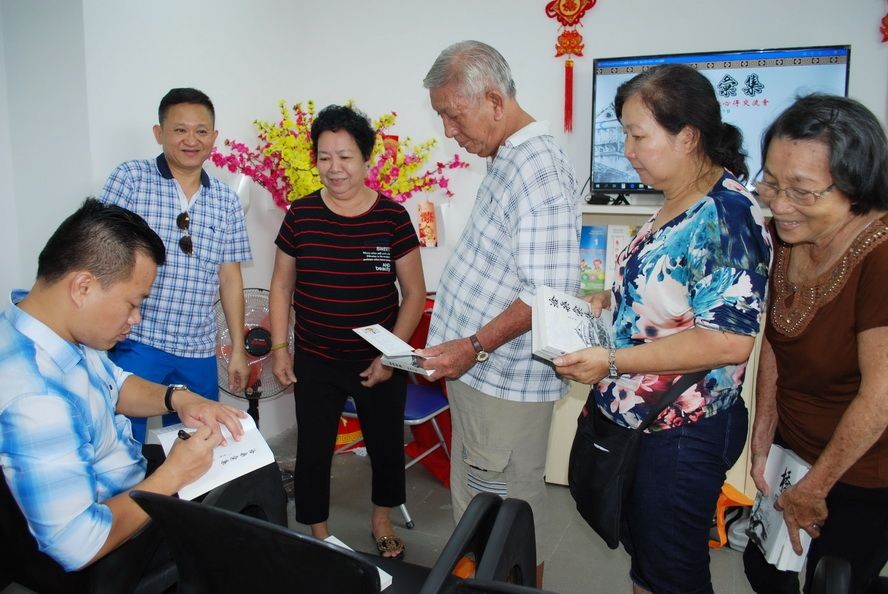 作者麒麟(左一)給華人讀者簽名贈書。