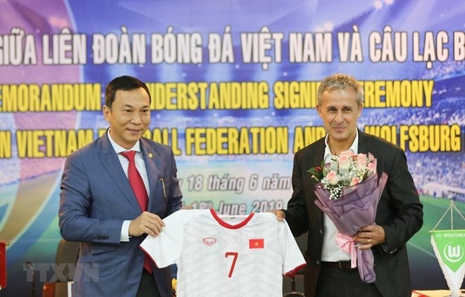 陳國俊副主席（左）向德國Wolfsburg隊大使贈送越南足球隊的衣服。（圖源：互聯網）