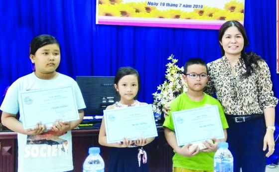 第五郡婦聯會主席陳氏秋香向清貧子弟頒發 “安東為學生接力”獎助學金。