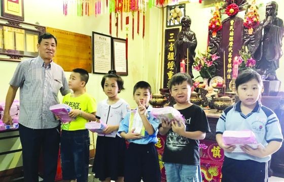 曾文良理事長向優秀小學生頒獎。