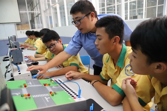 市技術經濟高等學校中級水平10年級學生正在電-電子實習課上。