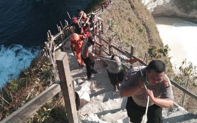 救援隊員將罹難者的屍體運出懸崖。（圖源：Nusa Bali）