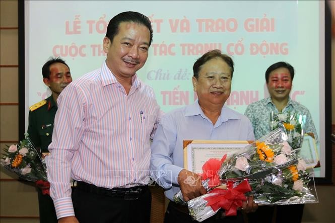 市文體廳副廳長武仲南（前左）向金甌省參賽者黎越鴻頒發一等獎并送鮮花祝賀。（圖源：越通社）