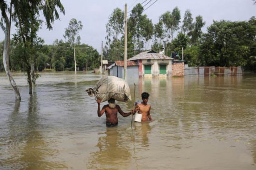 7月19日，孟加拉國戈伊班達洪災區的居民帶著財物涉水前進。（圖源：互聯網）