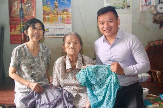 麒麟(右一)接受劉二女大娘(中)和葉雪梅 女士(左一)贈送擁有半個世紀歷史的大襟衫。