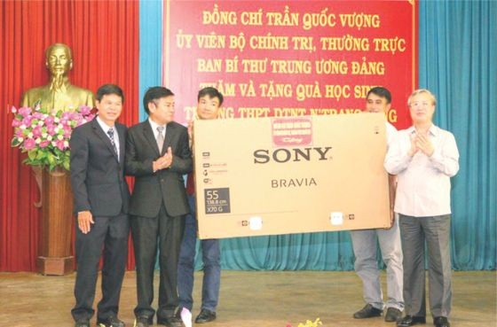 黨中央書記處常務書記陳國旺 (右)向達樂省尼莊隆少數民族寄宿 高中學校贈送電視機。（圖源：互聯網）