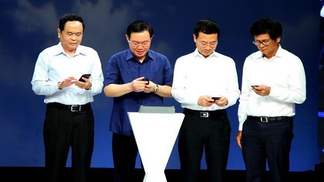政府副總理王廷惠（左二）同越南祖國陣線中央委員會主席陳清敏（左一）在響應“2019年全國攜手為貧民”行動儀式上發送捐助貧困者短訊。（圖源：真論）