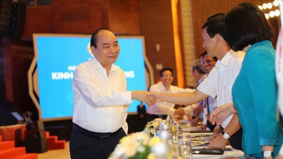 政府總理阮春福（左）同與會代表親切握手，互致問候。（圖源：PV）