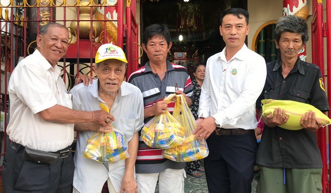 立案會長王奕謀(左一)與代表向窮人送禮物。