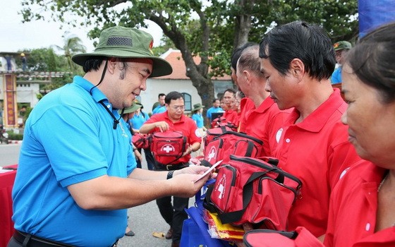 市勞動聯團常務委員副主席胡春霖（左）向崑崙島漁民贈送國旗和禮物。（圖源：勞動者報）