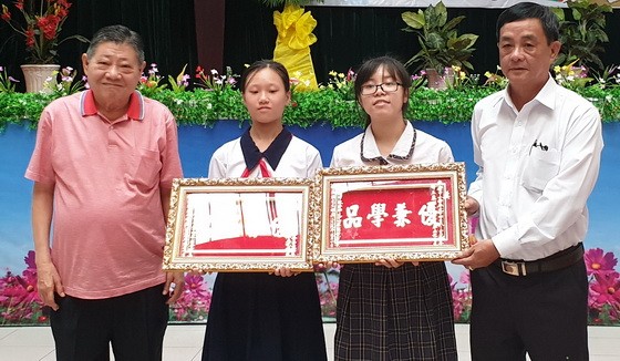 杭慰瑤董事長(左一)向學生頒發“品學兼優”金牌。