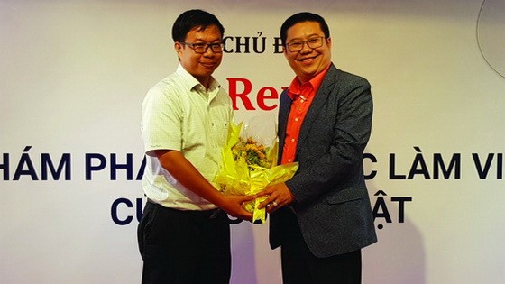 第五郡企業協會副主席、華人企業家周先識(右)送花感謝贊助單位。