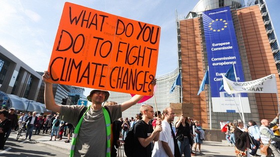在比利時布魯塞爾民眾手持標語參加氣候變化遊行。（圖源：新華社）