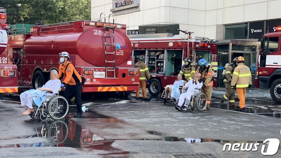 當地時間24日，韓國京畿道金浦市的一家護理醫院發生火災。圖為消防人員正在疏散患者。（圖源：News 1）