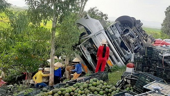 村民幫助司機撿拾散落在地面上的水果。