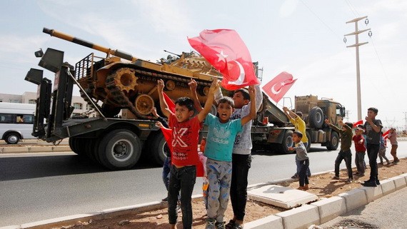 土坦克向敘邊境挺進，一些小孩子舉著土耳其國旗歡呼。（圖源：路透社）