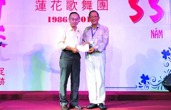 陳志華團長向本報編輯部主任 范興（左）轉交善款。