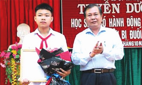 勇敢救溺水兒童的九年級A班學生潘忠孝（左）獲表彰。（圖源：越通社）