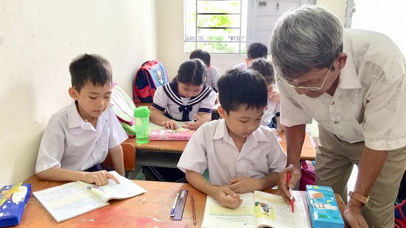 阮必友老師盡心為窮困兒童授課。