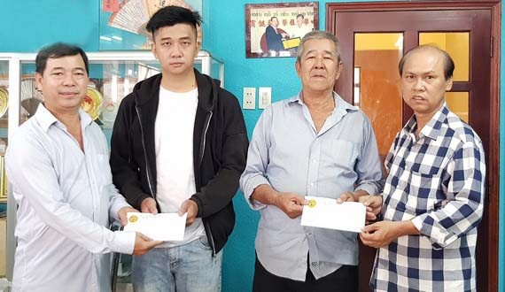 　　理事長馮傳坤(左一)和副理事長馮堯強 (右一)將款項交給馮滿朝及馮燕好兒子。