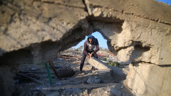 11月2日，在加沙地帶南部城市汗尤尼斯，一名巴勒斯坦人查看以軍空襲造成的廢墟。（圖源：新華社）