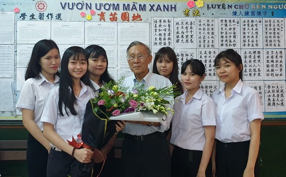 啟秀初中生向 55 年黨齡黨員、校長王沛川贈送鮮花。
