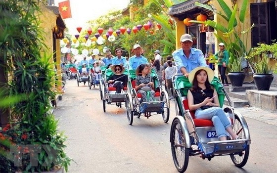 國際遊客坐三輪車參觀會安古埠。