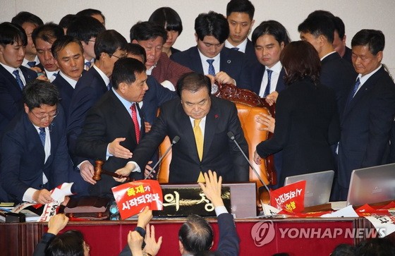 12月27日，在韓國國會，國會議長文喜相在自由韓國黨議員的阻擋下為《公職選舉法》修訂案表決結果落錘定音。（圖源：韓聯社）