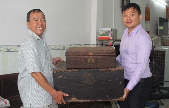 本報發行部老員工周志雄（左）向麒麟捐出多件極具歷史價值的華人文物。