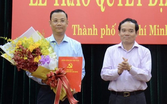 高山安同志（左）接領市委辦公廳副主任職務的《決定》。（圖源：B. Ngọc）