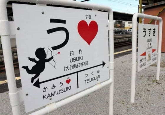 日本大分縣臼杵市在臼杵站和上臼杵站月台的站牌上，添加了“U ♡”標誌，以及活動期間限定版用弓箭瞄準愛心的天使圖案。（圖源：朝日新聞）