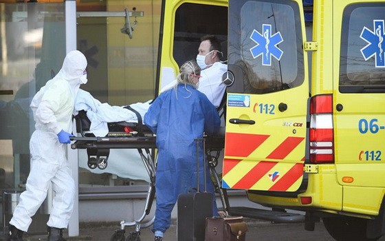 新冠疫情在荷蘭快速蔓延，救援人員送患者上救護車。（圖源：路透社）