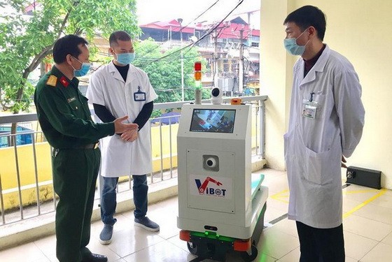 軍事技術學院代表人向北升龍醫院的醫生們介紹Vibot-1a機器人的功能。（圖源：安河）