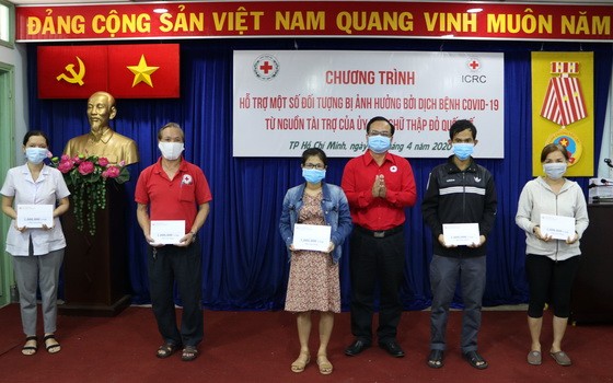越南中央紅十字會副主席武清流向貧困者贈送補助金。