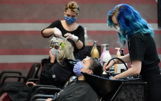 圖為美國佐治亞州瑪麗埃塔市的一家美髮店自24日重啟營業。（圖源：路透社）