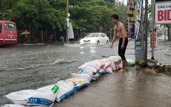 大雨導致守德郡的協平街淪為澤國，街道兩旁的民眾用麻袋來阻攔以避免雨水湧入住房。（圖源：黃燕）