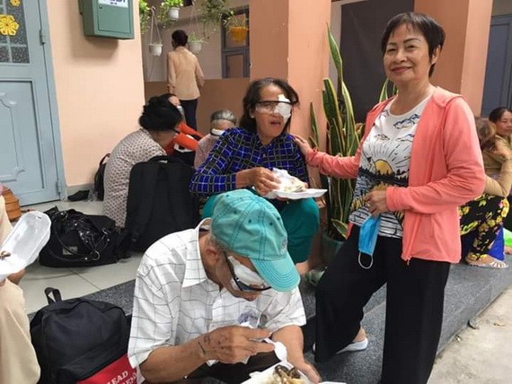 華人商販應氏蓮（右）向視障者派發營養餐。